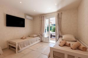 a bedroom with two beds and a tv and a window at Villa Soleil Et Douceur in La Seyne-sur-Mer +17 photos