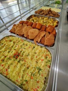 een buffet met veel verschillende soorten eten op dienbladen bij Hotel Nadia Eforie Nord in Eforie Nord +18 foto's