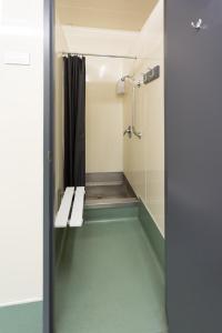 a bathroom with a shower with a bench in it at Urbanz in Christchurch