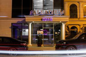 een auto geparkeerd voor een hotel bij Hotel Palladium in Odessa