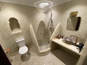 a bathroom with a toilet and a sink and a mirror at Riad Prada in Marrakech