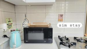 eine Mikrowelle auf einem Herd in der Unterkunft Sim stay심스테이-매일 침구세탁clean bed in Mŏnnae + 11 Fotos