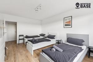 Habitación con 2 camas, paredes blancas y suelo de madera. en MONTEUR - Unterkunft für bis zu 6 Personen in 63454 Hanau - HU11, en Hanau am Main 3 fotos más