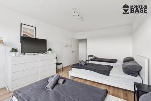 Habitación blanca con 2 camas y TV. en MONTEUR - Unterkunft für bis zu 6 Personen in 63454 Hanau - HU11, en Hanau am Main
