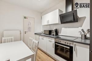 Una cocina con gabinetes blancos y un horno de estufa. en MONTEUR - Unterkunft für bis zu 6 Personen in 63454 Hanau - HU11, en Hanau am Main