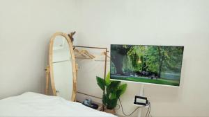 ein Schlafzimmer mit einem Bett und einem Fernseher an der Wand in der Unterkunft Sim stay심스테이-매일 침구세탁clean bed in Mŏnnae