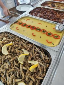 een buffet met verschillende dienbladen eten op tafel bij Hotel Nadia Eforie Nord in Eforie Nord