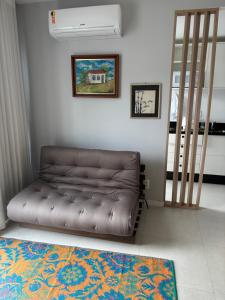a leather couch in a living room with a staircase at Apt próximo a UFSC in Florianópolis