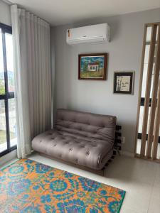 a brown couch in a room with a window at Apt próximo a UFSC in Florianópolis +10 photos