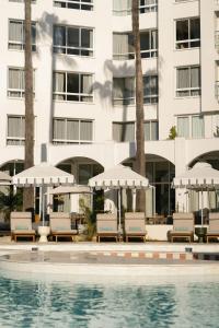 - une piscine avec des chaises et des parasols à côté d'un bâtiment dans l'établissement President Hotel, au Cap