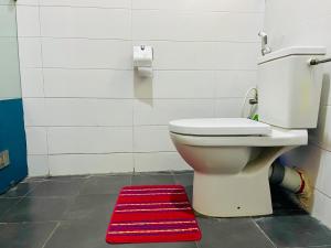Un baño con inodoro y una alfombra roja. en Modern 1bedroom in Bodija, en Ibadán