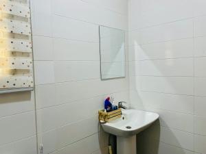 Un baño blanco con lavabo y espejo. en Modern 1bedroom in Bodija, en Ibadán