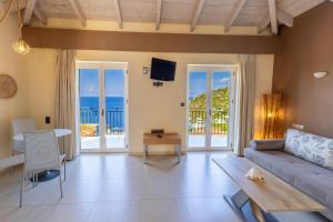 a living room with a couch and a table at Petani Bay Hotel - Adults Only in Vovikes