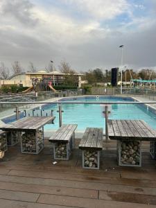 a swimming pool with picnic tables in front of it at Sunshine Lodge Haven Lakeland in Flookburgh