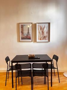 une table de salle à manger noire avec des chaises et des tableaux au mur dans l'établissement Bright 2BR Apartment in Central Vienna, à Vienne