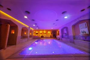 een groot zwembad in een kamer met paarse verlichting bij Hotel Palladium in Odessa