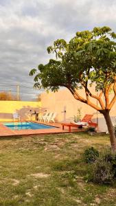 een boom in een tuin met een zwembad bij Quincho balderrama 