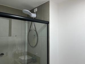 a shower with a shower head and a mirror at Aptos 1 ou 2 quartos no Centro com Piscina e Academia in Maringá +197 photos