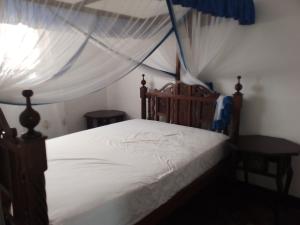 un dormitorio con una cama con dosel en Allison Homes, en Kilifi