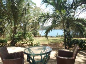 una mesa y sillas con una mesa de cristal y vistas al agua en Allison Homes, en Kilifi