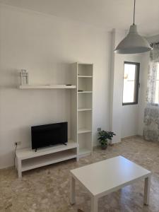 a living room with a tv and a white table at Copenhagen Lovely in Gran Tarajal +14 photos