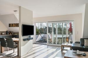 a living room with a flat screen tv and a table at Perle von Borkum 2 in Borkum