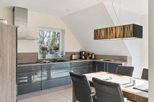 a kitchen with a table and chairs in a room at Perle von Borkum 2 in Borkum