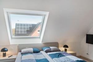 a bedroom with a large window above a bed at Perle von Borkum 2 in Borkum