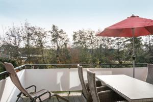 a balcony with a table and an umbrella at Perle von Borkum 2 in Borkum