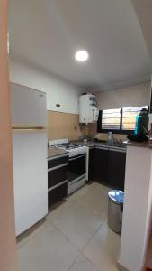 a kitchen with white appliances and a white refrigerator at Duplex Villa Carlos Paz in Villa Carlos Paz