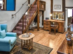 ein Wohnzimmer mit einer Treppe und einem Tisch in der Unterkunft The Old Sweet Shop in Kings Lynn