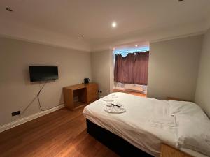 ハイ・ウィカムにあるCavendish Hotelのベッドと薄型テレビのある寝室