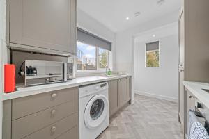 a kitchen with a washing machine and a microwave at Harbour Hideaway in Fife +16 photos