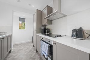 a kitchen with white cabinets and a counter top at Spacious 2 Bed Apartment - Perfect for Long or Short Stays - Sleeps 4 - Free On Street Parking in Fife +16 photos