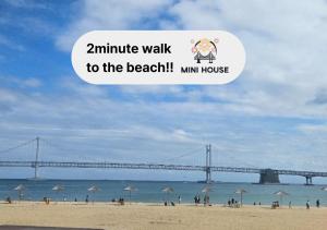 a view of the beach with a bridge in the background at Mini House in Busan