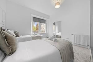 a white bedroom with a large bed and a window at Spacious 2 Bed Apartment - Perfect for Long or Short Stays - Sleeps 4 - Free On Street Parking in Fife