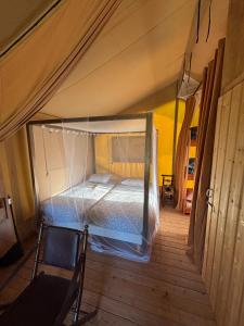 a bedroom with a bed in a tent at Lodge La Forêt in Saint-Sauveur