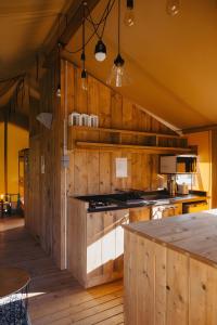 a kitchen with wooden walls and a counter top at Lodge La Forêt in Saint-Sauveur