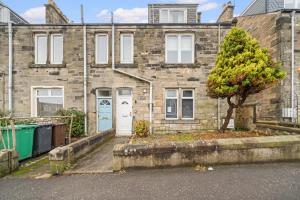 a brick house with a tree in front of it at Harbour Hideaway in Fife
