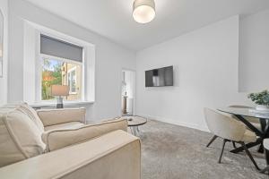 a living room with a couch and a table at Harbour Hideaway in Fife