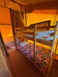 a bunk bed in a room with a flower blanket at Lodge Les Étoiles in Saint-Sauveur
