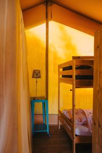 a bedroom with a bunk bed and a table with a lamp at Lodge Les Étoiles in Saint-Sauveur