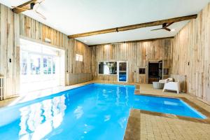 a swimming pool in a house with wooden walls at Au p'tit tcheste in Hontanx
