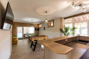 a living room with a pool table and a kitchen at Au p'tit tcheste in Hontanx