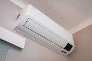 a white air conditioner hanging from a ceiling at Orange Blossom Grove in Cerro das Taipas +46 photos