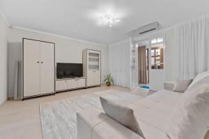 un soggiorno bianco con letto e TV di Casa Albă a Roman