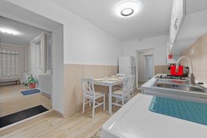 una cucina con un lavello e un tavolo con sedie di Casa Albă a Roman