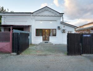 una casa bianca con un cancello davanti di Casa Albă a Roman