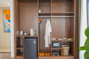 ダナンにあるNesta Celia Da Nang Hotelの冷蔵庫付きの食器棚