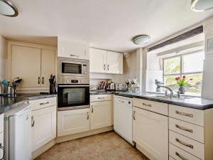 a kitchen with white cabinets and stainless steel appliances at 4 Bed in Buttermere SZ090 in Buttermere +31 photos